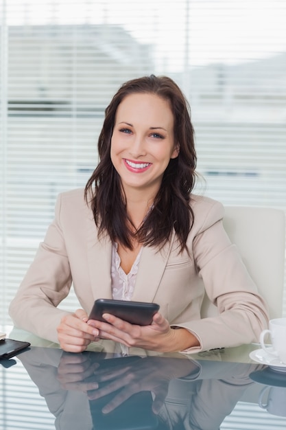 Smiling businesswoman working on her tablet pc