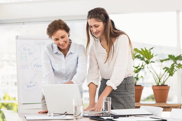 Sorridente imprenditrici utilizzando il computer portatile