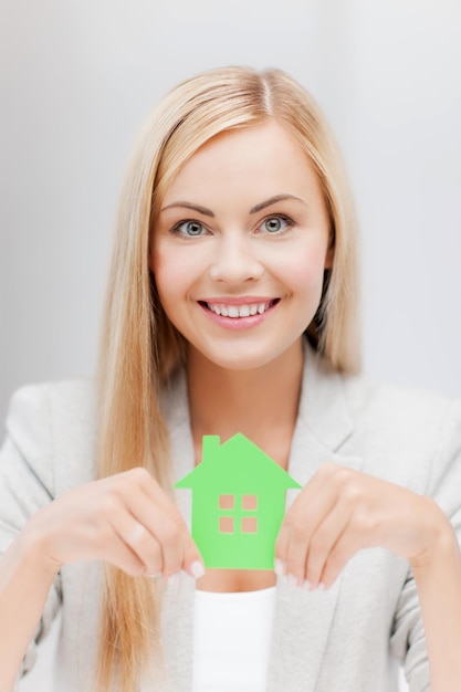 smiling busineswoman with green eco house symbol