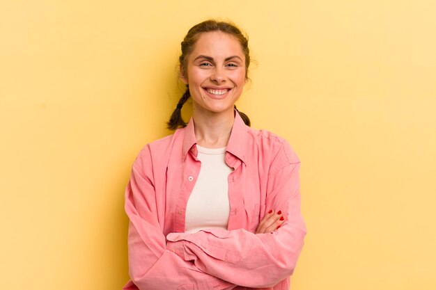 Smiling to camera with crossed arms and a happy confident satisfied expression lateral view