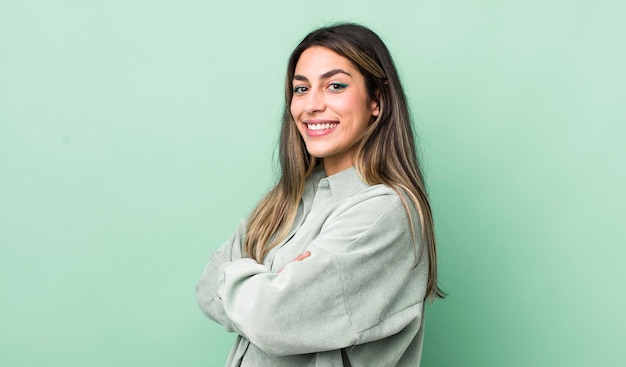 Smiling to camera with crossed arms and a happy confident satisfied expression lateral view