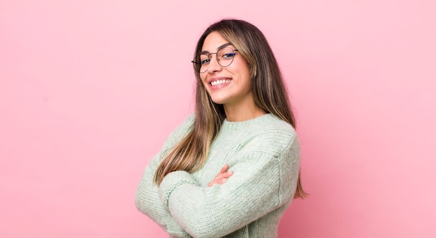 Smiling to camera with crossed arms and a happy confident satisfied expression lateral view