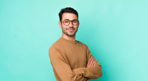 Smiling to camera with crossed arms and a happy confident satisfied expression lateral view