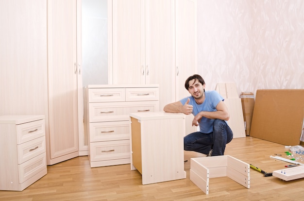 Smiling carpenters of furniture thumbs up