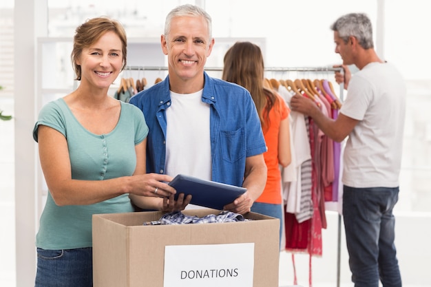 Foto colleghi casuali sorridenti di affari con la scatola di donazione