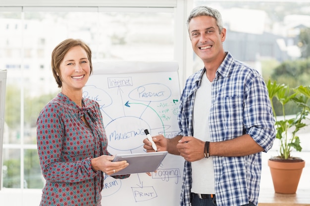 Smiling casual business colleagues with tablet