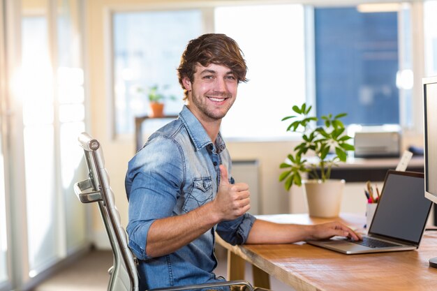 Smiling casual businessman sitting at desk