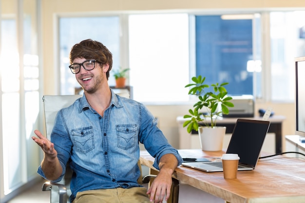 Smiling casual businessman sitting at desk