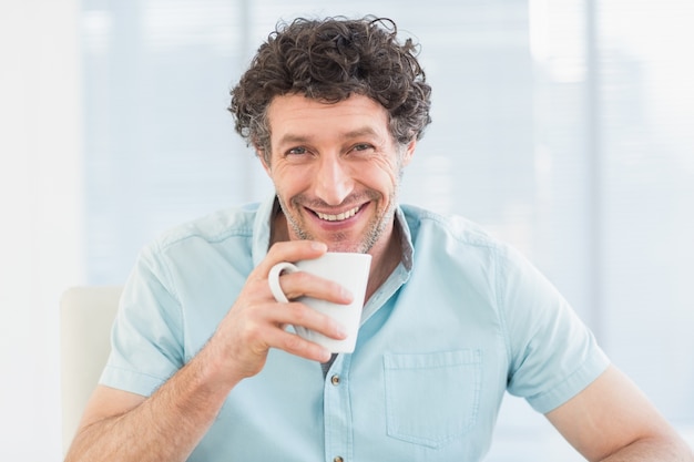 Smiling casual businessman sitting at desk