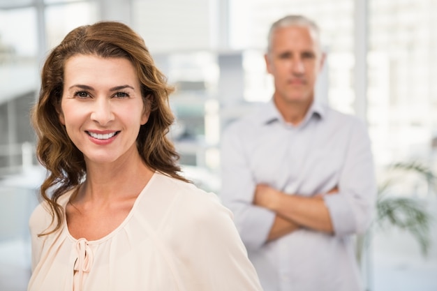 Smiling casual businesswoman in front of her colleague