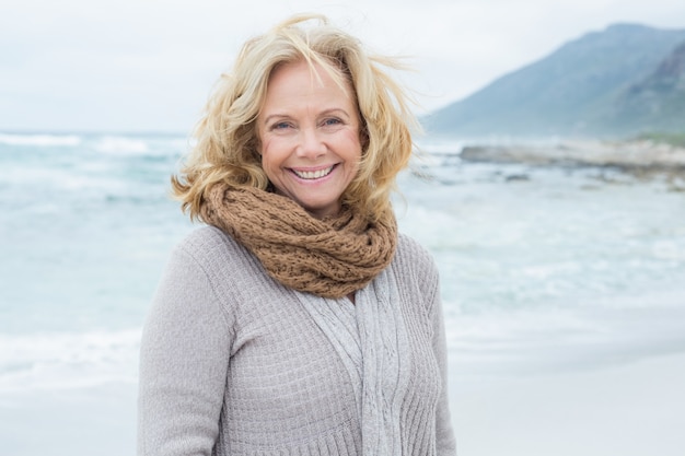 Smiling casual senior woman relaxing at beach