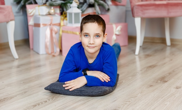 Smiling caucasian boy opening presents during christmas eve