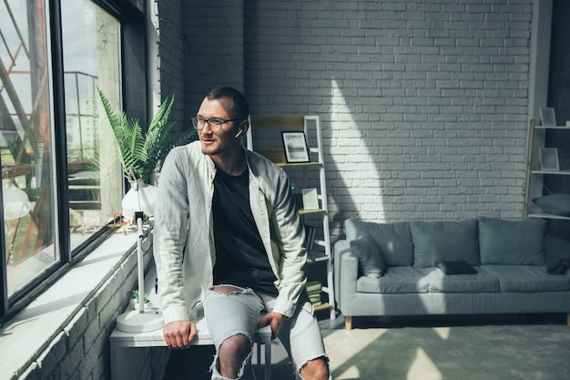 Photo smiling caucasian businessman portrait leaning against a table sitting alone in his office business portrait businessman manager employee