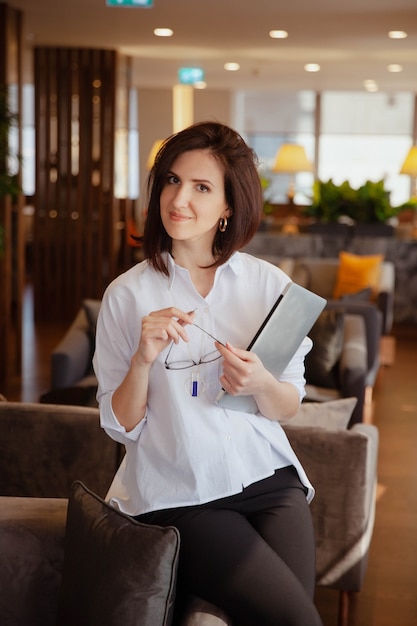 Smiling Caucasian businesswoman holding laptop computer