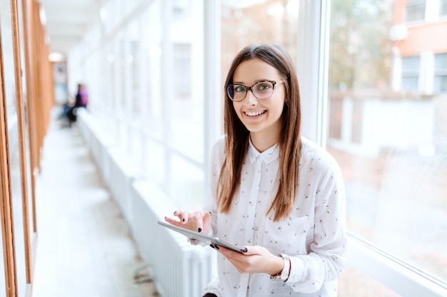 Smiling Caucasian collage girl using tablet