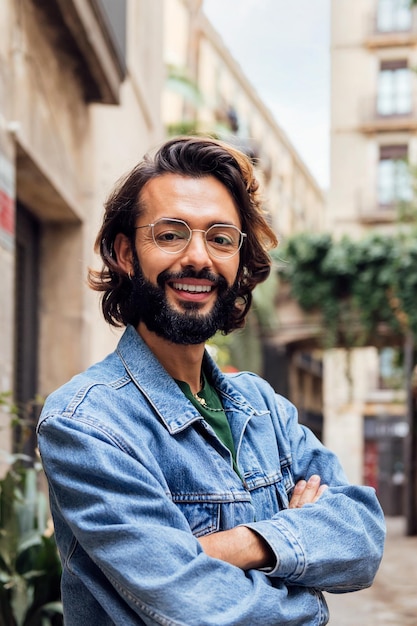 Smiling caucasian man with arms crossed at street