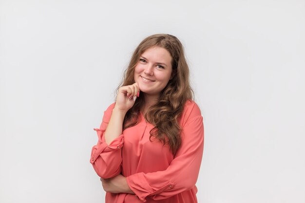 Smiling caucasian plump girl with natural make up in red shirt looking at camera She is enjoying life