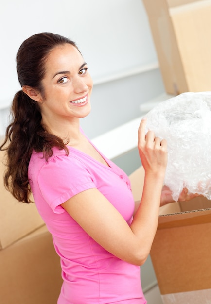 Photo smiling caucasian woman unpacking boxes with glasses