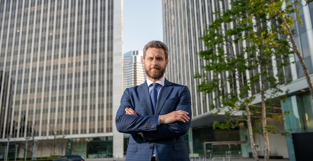 Smiling charismatic mature businessman in suit outside the office charisma