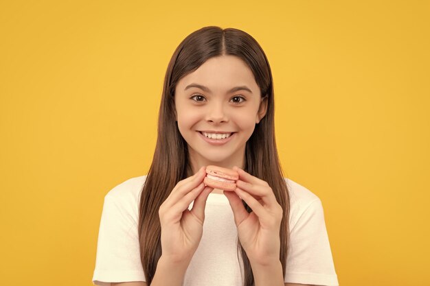 Smiling cheerful child with dessert bakery kid hold french macaron macaroon cookie