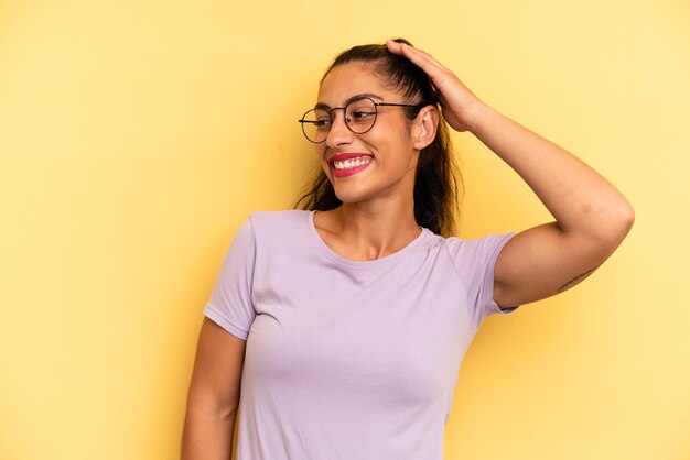 Sorridendo allegramente e con disinvoltura, prendendosi mano a testa con uno sguardo positivo, felice e sicuro di sé