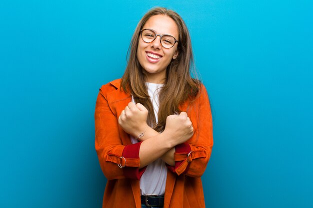 Foto sorridendo allegramente e festeggiando, con i pugni chiusi e le braccia incrociate, sentendosi felice e positivo