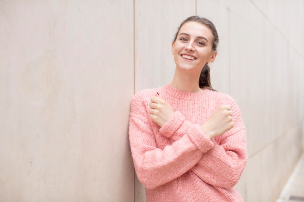 Photo smiling cheerfully and celebrating with fists clenched and arms crossed feeling happy and positive