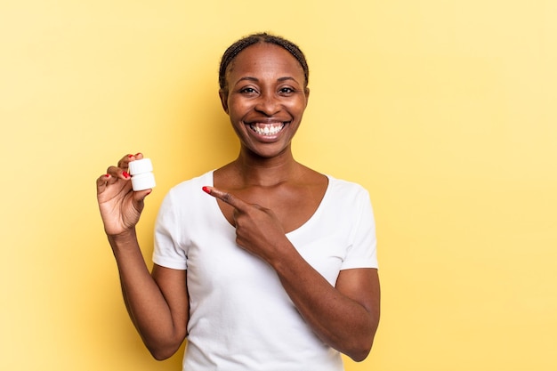 Sorridere allegramente, sentirsi felici e puntare di lato e verso l'alto, mostrando l'oggetto nello spazio della copia. concetto di pillole