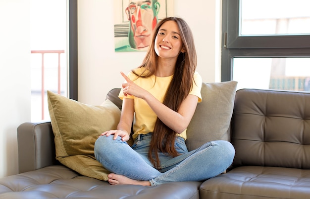 Foto sorridendo allegramente, sentendosi felice e indicando di lato e verso l'alto, mostrando l'oggetto nello spazio della copia