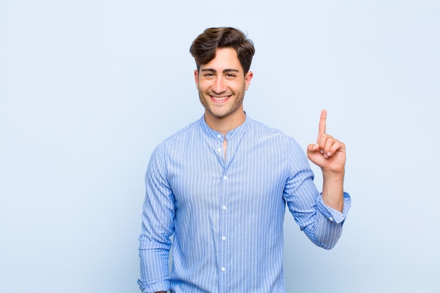 smiling cheerfully and happily, pointing upwards with one hand