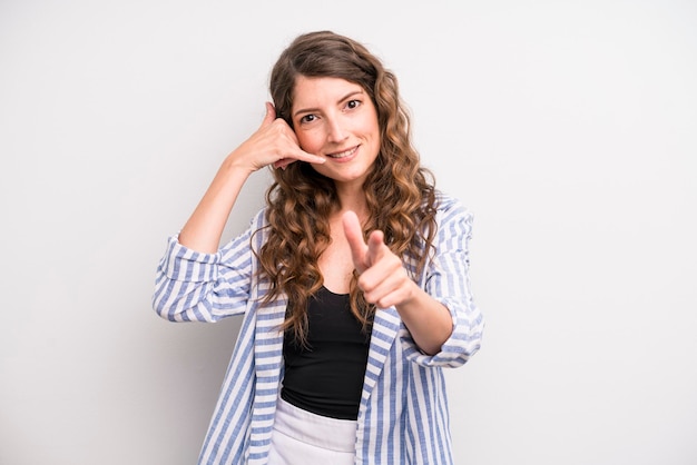 Photo smiling cheerfully and pointing to camera while making a call you later gesture talking on phone