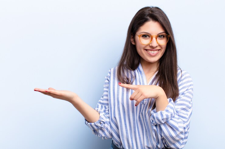 Photo smiling cheerfully and pointing to copy space on palm on the side, showing or advertising an object