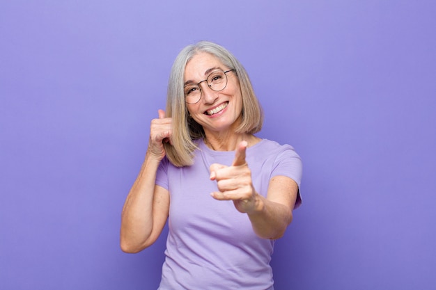 smiling cheerfully and pointing at front while making a call you later gesture, talking on phone