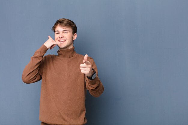 smiling cheerfully and pointing at front while making a call you later gesture, talking on phone