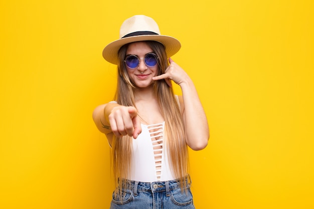 smiling cheerfully woman pointing while making a call you later gesture, talking on phone