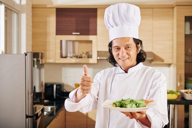 Smiling chef with tasty dish