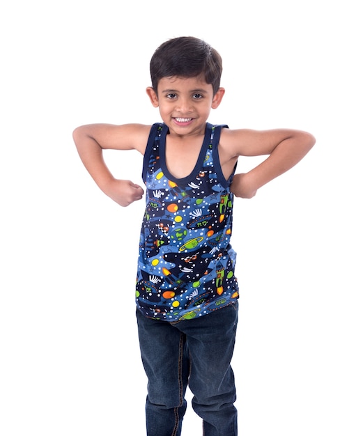 Улыбающийся мальчик ребенка показывая его силу мышц бицепса руки на белой предпосылке.