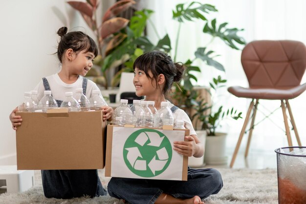 Smiling children having fun while segregating plastic bottles and paper into a bin