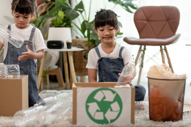 ペットボトルと紙をビンに分けながら楽しんでいる笑顔の子供たち