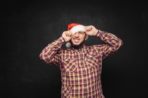 Smiling christmas man wearing a santa hat isolated on black