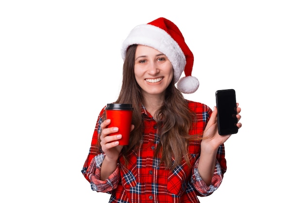 Smiling Christmassy woman is showing the screen of her phone to the camera.