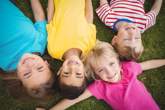 Smiling classmates lying in grass