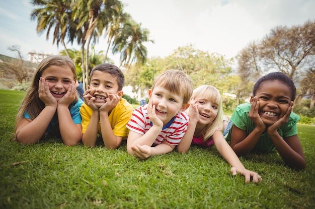 Compagni di classe sorridenti che si trovano in una fila in erba