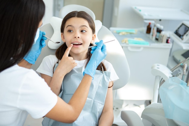 Smiling client at dental procedure dentist using dental instruments in modern dental clinic