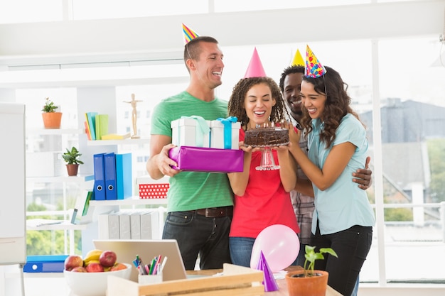 Photo smiling colleagues celebrating birthday in the office