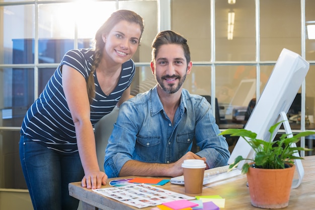 Smiling colleagues working together on computer