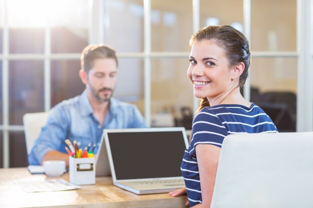 Smiling colleagues working together on laptop