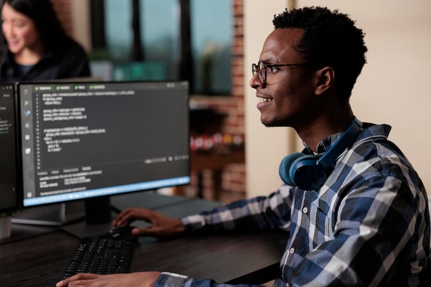 Smiling confident african american software engineer developing machine learning algorithm in order to sustain system security stability. cyber developer creating network using binary encryption.