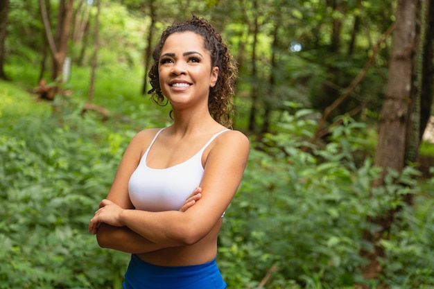 Smiling confident afro american woman with crossed arms posing outdoors. Relax, leisure, female beauty concept