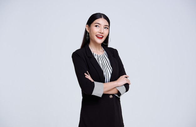 Smiling Confident Asian business woman over gray background.